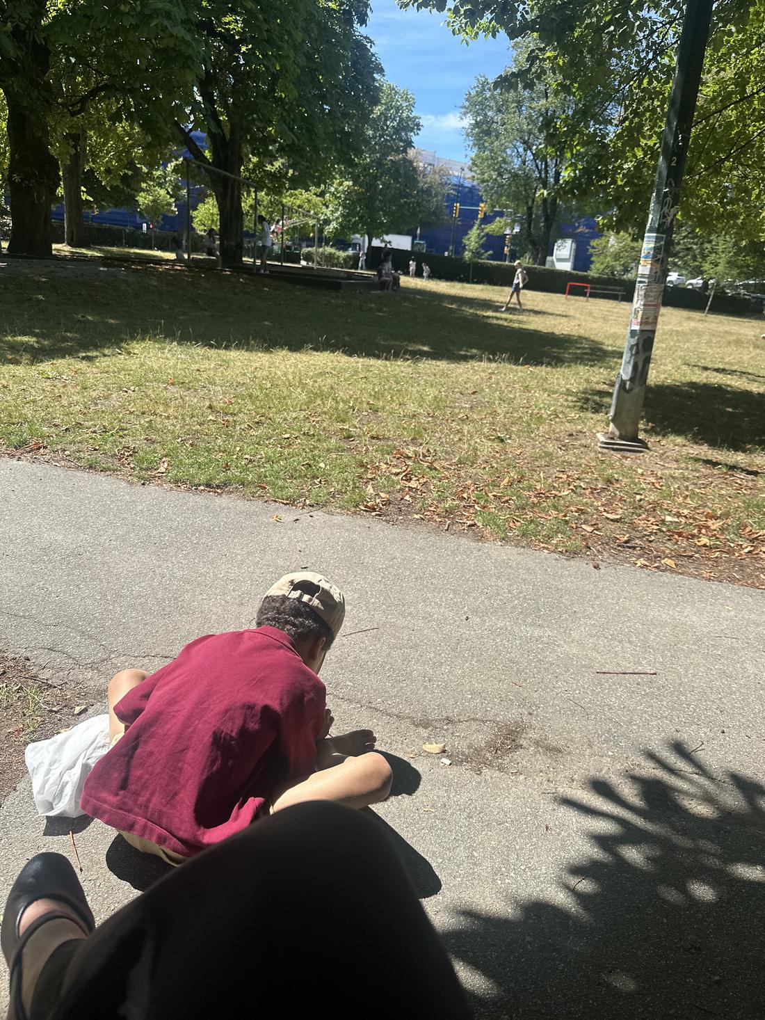 A child exploring outdoors on a park path.
